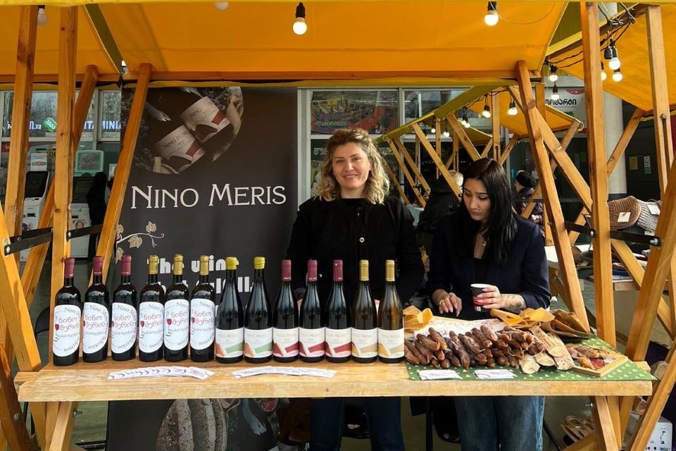 Founder and director of the company "Nino Merry's", Nino Meris Madzgharashvili at the Christmas market in front of her wine products. Photo: UN Women