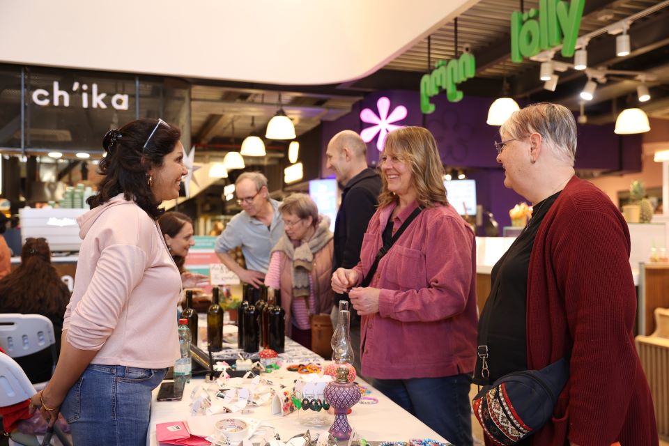 Guests of the exhibition are getting acquainted with the products of one of the women entrepreneurs. Photo: UN Women